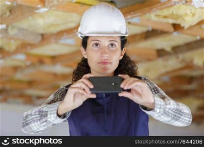 woman builder taking a phone with mobile phone