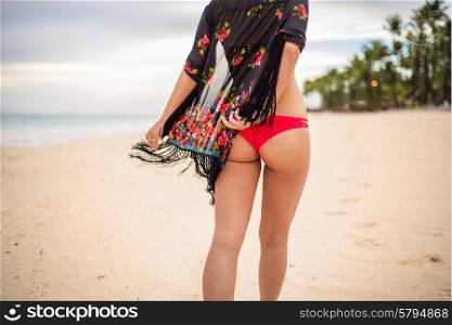 Woman buttocks on the beach background wearing red bikini