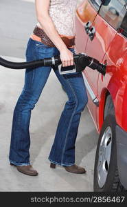 Woman by car with fuel pump