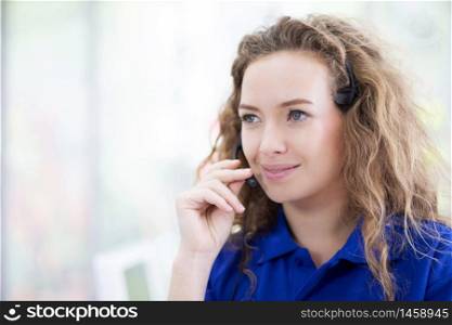 Woman call-center agent with headset working on support hotline in the office