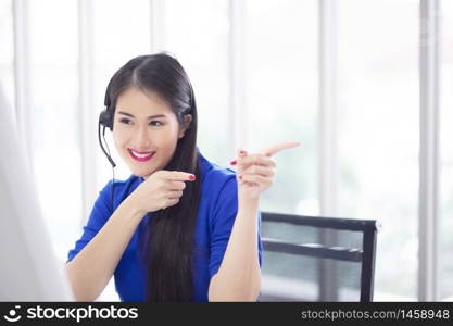 Woman call-center agent with headset working on support hotline in the office