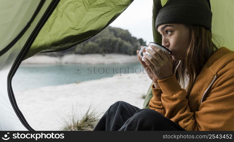 woman camping drinking tea sideways