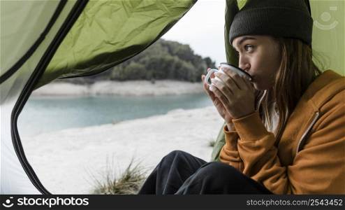 woman camping drinking tea sideways