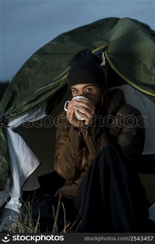 woman camping night with cup tea