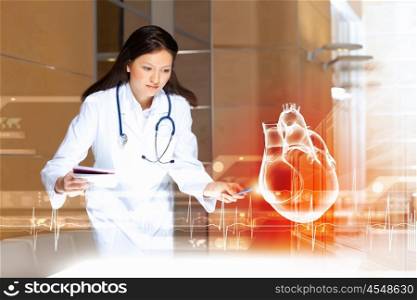 Woman cardiologist. Image of attractive woman cardiologist examining virtual heart