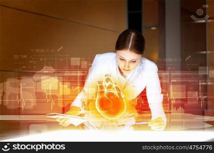 Woman cardiologist. Image of attractive woman cardiologist examining virtual heart