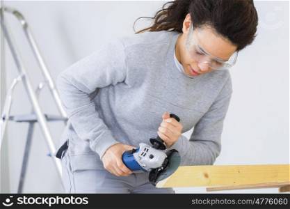 woman carpenter using an angle grinder