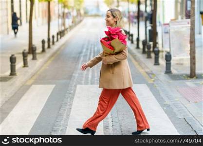 Woman carrying a poinsettia she has just bought in a plant shop. Typical Christmas decoration flower.. Woman carrying a poinsettia she has just bought in a plant shop.
