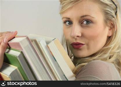Woman carrying a stack of books