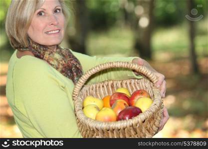 Woman carrying basket of apples