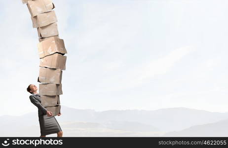 Woman carrying carton boxes. Woman in suit carrying stack of carton boxes