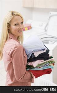 Woman Carrying Folded Up Laundry