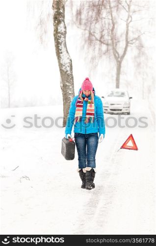 Woman carrying gas can snow car trouble winter breakdown walking