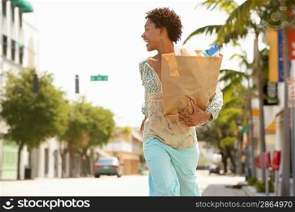Woman Carrying Grocery Bag While Walking