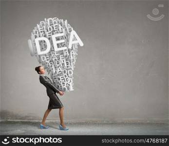 Woman carrying out her idea. Young businesswoman carrying idea light bulb in hands