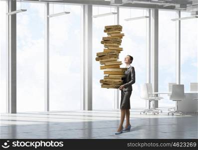 Woman carrying stack of books. Attractive businesswoman carrying pile of books in hands