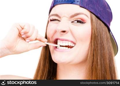 Woman casual style smiling teen girl holding a stick of chewing gum on white background. Youth style. Woman eating chewing gum