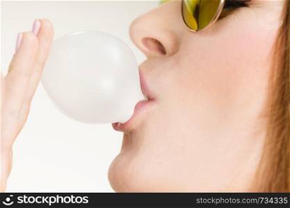 Woman casual style teen girl sunglasses doing bubble with chewing gum closeup. Youth style. Woman doing bubble with chewing gum