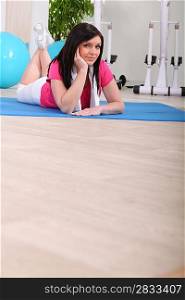 Woman casually laying on gym mat