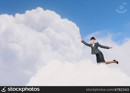 Woman catch cloud. Young businesswoman in bowler hat on cloud