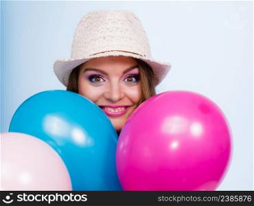 Woman charming girl playing with many colorful balloons. Summer, celebration happiness and lifestyle concept. Studio shot blue background. Woman playing with many colorful balloons