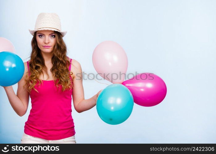 Woman charming girl playing with many colorful balloons. Summer, celebration happiness and lifestyle concept. Studio shot blue background. Woman playing with many colorful balloons