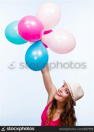 Woman charming girl playing with many colorful balloons. Summer, celebration happiness and lifestyle concept. Studio shot blue background. Woman playing with many colorful balloons