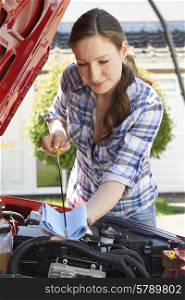 Woman Checking Car Engine Oil Level Under Hood With Dipstick