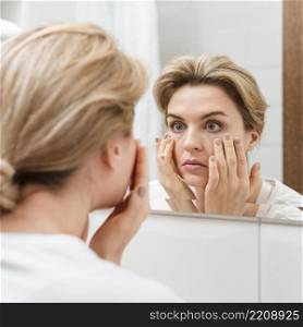 woman checking her eyes mirror
