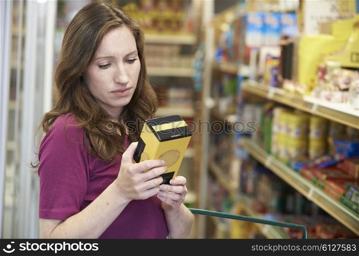 Woman Checking Labelling On Box In Supermarket