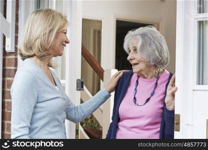 Woman Checking On Elderly Female Neighbor