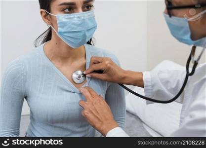 woman checking patient with stethoscope