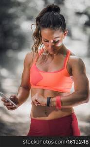 Woman checking progress on smart watch after training outdoors