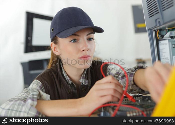 woman checking the voltage of a machine