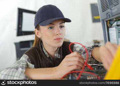 woman checking the voltage of a machine