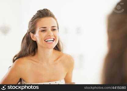 Woman checking tooth in bathroom