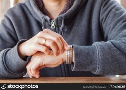 Woman checks the time on a wrist watch, stock photo