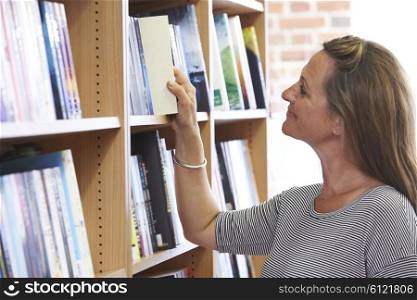 Woman Choosing A Book In Bookstore