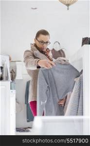 Woman choosing sweater in store
