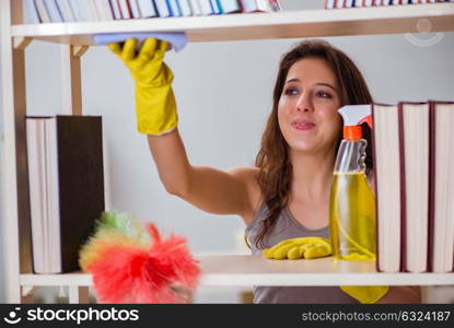 Woman cleaning dust from bookshelf