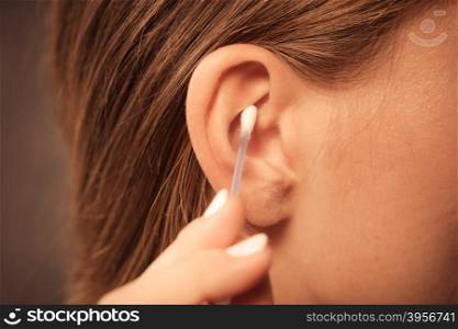 Woman cleaning ear with cotton swabs closeup . Hygiene concept. Woman cleaning ear with cotton swabs closeup