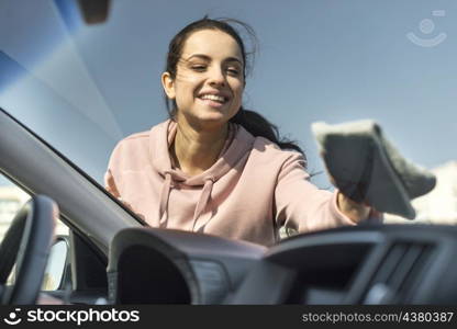 woman cleaning front windscreen her car