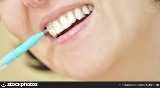 woman cleaning her teeth with an interdental brush