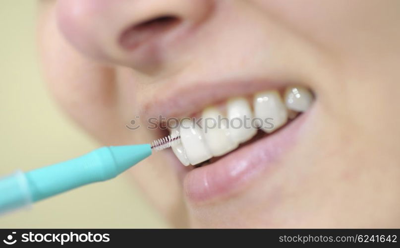 woman cleaning her teeth with an interdental brush