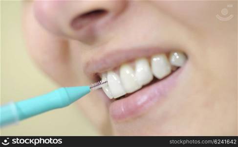 woman cleaning her teeth with an interdental brush