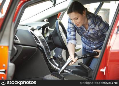 Woman Cleaning Interior Of Car Using Vacuum Cleaner