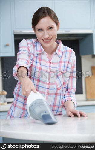 Woman Cleaning Kitchen Using Hand Held Vacuum Cleaner