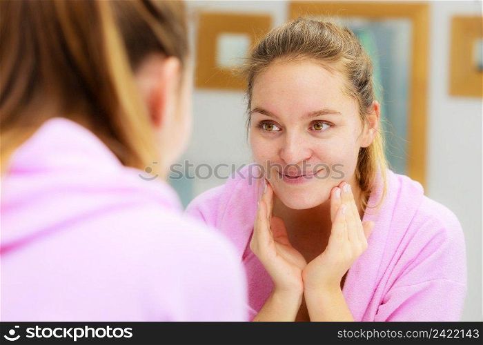 Woman cleaning peeling her face in bathroom, making facial massage with scrub. Girl taking care of skin condition. Hygiene. Skincare spa treatment. . Woman cleaning her face with scrub in bathroom.