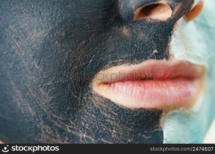 Woman cleaning skin face, using green mud and carbo black mask. Girl taking care of oily complexion. Beauty procedures. Skincare.. Girl black and green mud mask on face