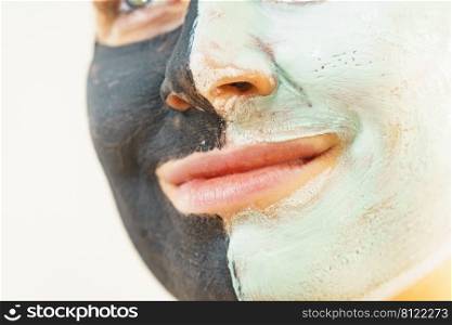 Woman cleaning skin face, using green mud and carbo black mask. Girl taking care of oily complexion. Beauty procedures. Skincare.. Girl black and green mud mask on face